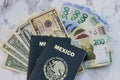 High angle view of two Mexican Passports on dollars and pesos on the table under the lights