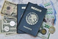 High angle view of two Mexican Passports on dollars and pesos on the table under the lights