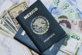 High angle view of two Mexican Passports on dollars and pesos on the table under the lights