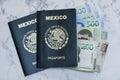 High angle view of two Mexican Passports and pesos on the table under the lights