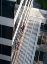 High Angle View of Two Window Washers Standing on a Suspended Scaffold and Cleaning Office Building Windows