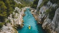 High angle view of unrecognizable people kayaking on blue narrow river flowing between rocky mountains during vacation at daytime