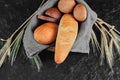 High angle view of variety freshly homemade bread in wooden basket with tablecloth