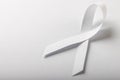 High angle view of white lung cancer awareness ribbon isolated against white background, copy space