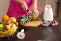 Cutting a pineapple top with a kitchen knife Royalty Free Stock Photo