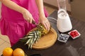 Woman cutting pineapple with a kitchen knife Royalty Free Stock Photo