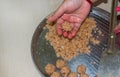 High angle view of a woman making homemade sweet, coconut laddu for festive season on a domestic table. Close up and selective Royalty Free Stock Photo