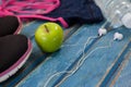 High angle view of womenswear with Granny Smith apple and headphones