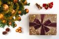 High angle view of a wrapped gift, a collection of Christmas ornaments and a plastic pine tree on a white background.