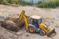 High angle view of yellow mini excavator on construction site digging a pit Royalty Free Stock Photo