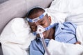 Man Wearing CPAP Mask Sleeping On Bed