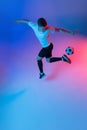 High angle view of young man, male soccer football player training isolated on gradient blue pink background in neon Royalty Free Stock Photo