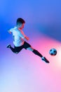 High angle view of young man, male soccer football player training isolated on gradient blue pink background in neon Royalty Free Stock Photo