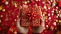 High angle of woman hands holding diagonally gift box wrapped with red ribbon over red background Royalty Free Stock Photo