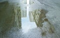 High buildings reflecting on puddle after rain Royalty Free Stock Photo