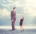 High businessman looking down at little woman in Royalty Free Stock Photo