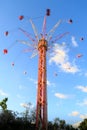 High carousel is whirling on the background of blue sky in park Royalty Free Stock Photo