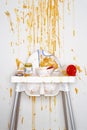 High chair with bowl spoon jar and stains of baby food view from above