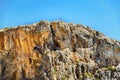 High cliff with Greek fkag on top. Agiofarango gorge. Royalty Free Stock Photo