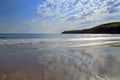 High clouds above the headland, reflected in the wet sands of Aberdaron Beach and bay