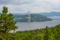 High Coast Bridge, a cable stayed structure in Sweden, spans two islands over Angermanalven river beneath a cloudy sky, framed by Royalty Free Stock Photo