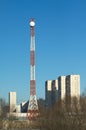 High communication tower with round antenna in a city