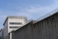 High concrete fence, barbed wire fence on top, pre-trial detention cell, building for execution of punishments for criminals, Royalty Free Stock Photo
