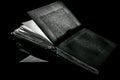 High contrast black and white image of an old book on black reflective surface Royalty Free Stock Photo