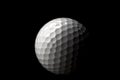 High contrast studio shot of golf ball isolated on black background with dramatic light