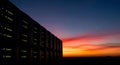 Photorealistic silhouette of advanced data center server racks stands dramatically against a vivid sunset sky, symbolizing success Royalty Free Stock Photo