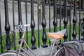 High contrast view of student bicycles seen chained up against a wrought Iron fence.