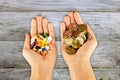 High cost of medical pills concept with piles of coins and pharmaceutical drugs in woman hands with wooden background Royalty Free Stock Photo