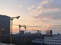 High cranes over buildings at sunset Royalty Free Stock Photo