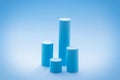 High cylindrical podiums on pastel blue background. Empty showcase design mockup for promotion sale, presentation of cosmetic