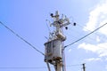 High Electric voltage wires and pole power lines,electric towers,power transformer against vibrant blue sky, clouds and sun. Royalty Free Stock Photo