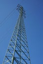 High electricity pylon during the sunny day with bright sun and blue sky Royalty Free Stock Photo