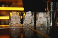 High-end bar, showcasing four crystal-clear whiskey glasses filled with ice cubes ready for cocktail Royalty Free Stock Photo