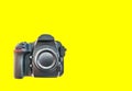 High end dslr camera front view, isolated on a yellow background Royalty Free Stock Photo