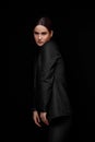 High fashion expressive portrait of young elegant woman in black suit and beige top. Studio shot