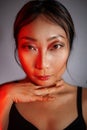 Asian woman in neon colorful bright lights posing in studio, portrait of a beautiful sexy girl with trendy makeup Royalty Free Stock Photo