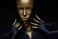 High fashion model with black and gold leather, golden fingers. Isolated on black background Beauty female face,