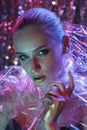 High Fashion model girl in colorful bright neon lights posing in studio through transparent film. Portrait of beautiful Royalty Free Stock Photo