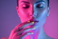 High Fashion model girl in colorful bright UV lights posing in studio, portrait of beautiful woman with trendy make-up Royalty Free Stock Photo