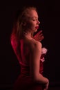 High Fashion model woman in colorful bright lights posing in studio, In a short red dress with white fur Royalty Free Stock Photo