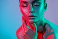 High Fashion model woman in colorful bright silver sparkles and neon lights posing in studio, portrait of beautiful girl Royalty Free Stock Photo