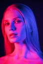 High fashion model woman& x27;s face in colorful bright neon UV blue and purple lights. Glitter bright neon makeup. Royalty Free Stock Photo