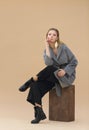 High fashion portrait of young elegant woman in Grey coat, black pants, black ankle boots and gold earrings Royalty Free Stock Photo