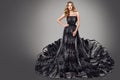 High Fashion Woman in Black Luxury Dress. Blonde Model in Long Glitter Tulle Gown. Women Party Make up and Curly Hair Style Royalty Free Stock Photo