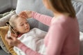 High Fever. Mom Checking Temperature Of Her Sick Daughter Sleeping On Couch Royalty Free Stock Photo