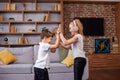 Children jump and dance at home while listening to music on headphones. Having fun. Family concept Royalty Free Stock Photo